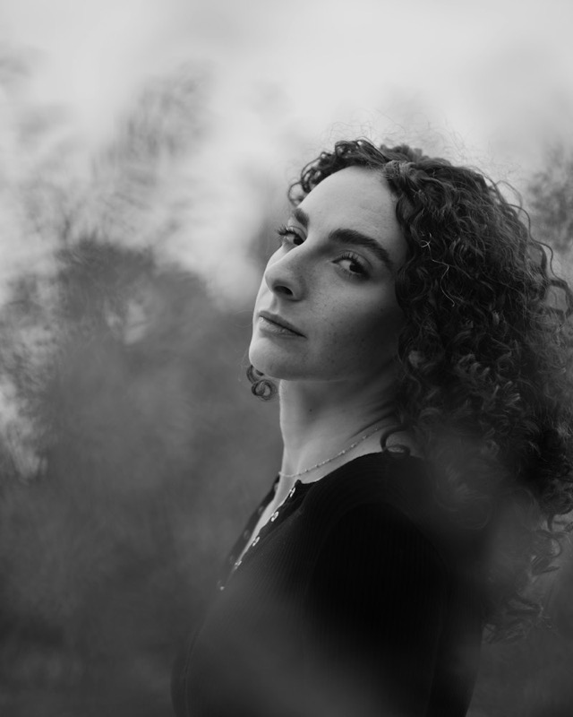 Black and white portrait of a woman with curly hair in soft haze