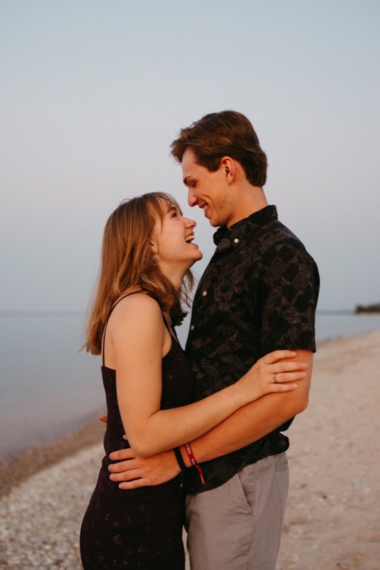 A couple embracing and laughing on a sandy beach